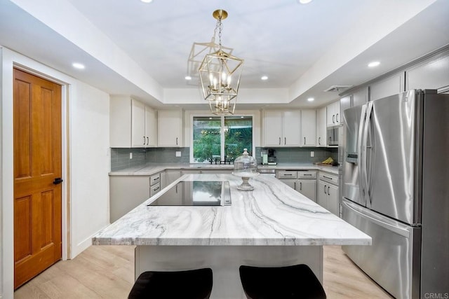 kitchen with decorative light fixtures, backsplash, stainless steel fridge with ice dispenser, and a kitchen island