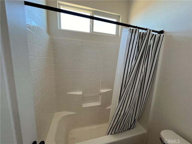 bathroom featuring shower / bath combination with curtain and toilet