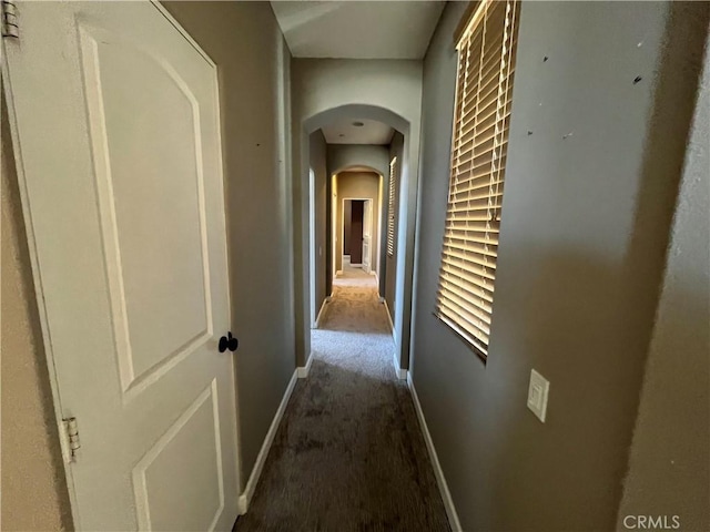 hallway featuring dark carpet