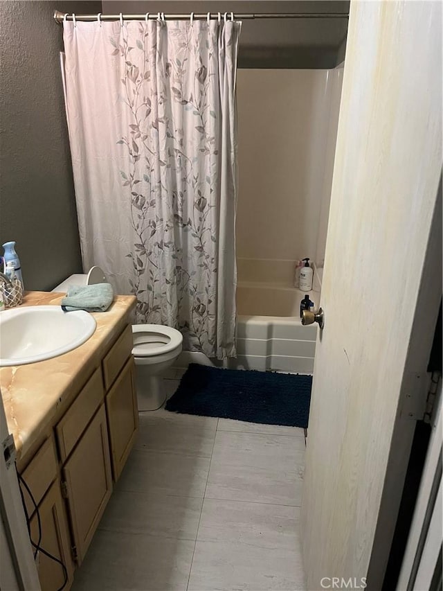 full bathroom featuring tile patterned floors, vanity, toilet, and shower / bath combo with shower curtain