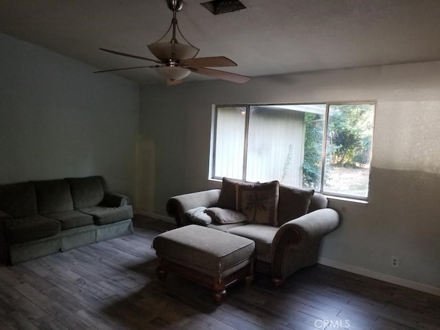 living room with dark hardwood / wood-style flooring and ceiling fan