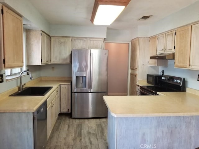 kitchen featuring sink, kitchen peninsula, light brown cabinetry, and black appliances