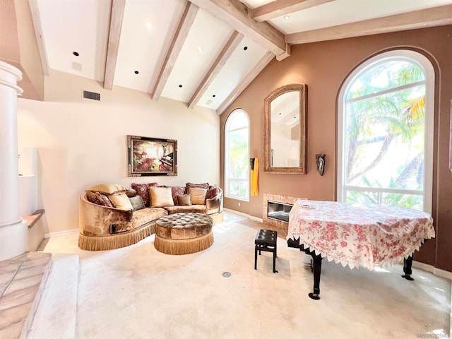 sitting room with lofted ceiling with beams, light colored carpet, and plenty of natural light