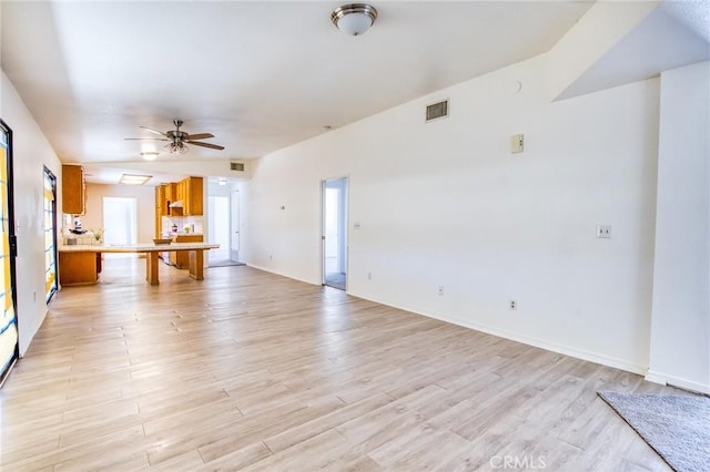 unfurnished living room featuring ceiling fan and light hardwood / wood-style floors