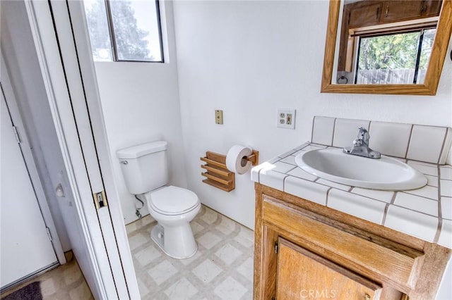 bathroom with vanity, a healthy amount of sunlight, and toilet