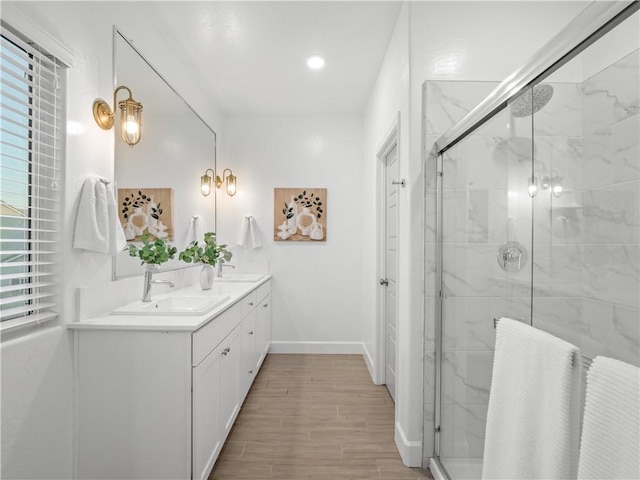 bathroom with hardwood / wood-style floors, vanity, and a shower with door