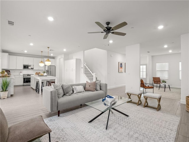 living room featuring ceiling fan and light wood-type flooring