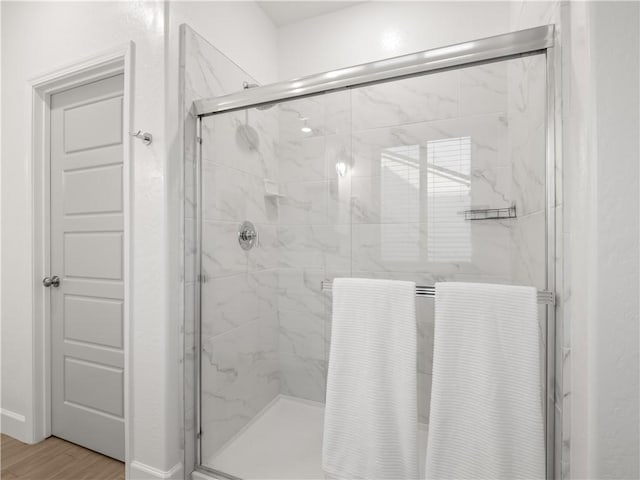 bathroom featuring hardwood / wood-style floors and a shower with door