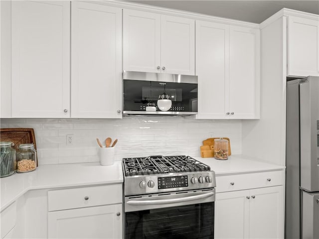 kitchen with backsplash, stainless steel appliances, and white cabinetry