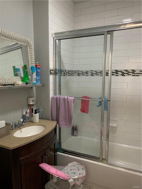 bathroom featuring vanity and bath / shower combo with glass door