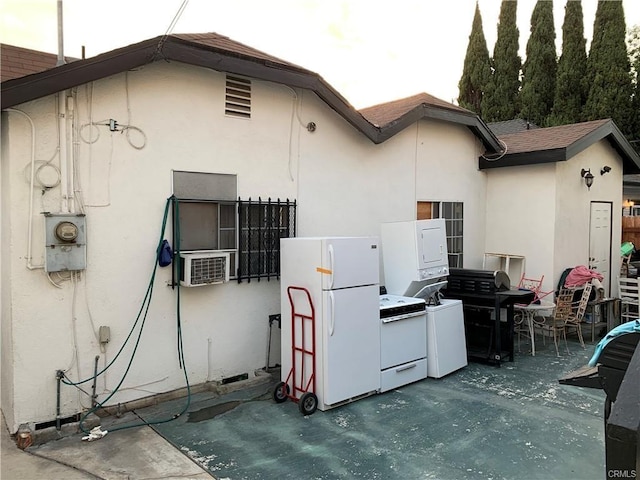 exterior space with cooling unit, a patio, and stacked washer / drying machine