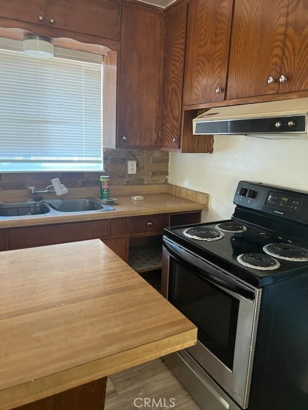 kitchen featuring electric range, hardwood / wood-style flooring, and sink