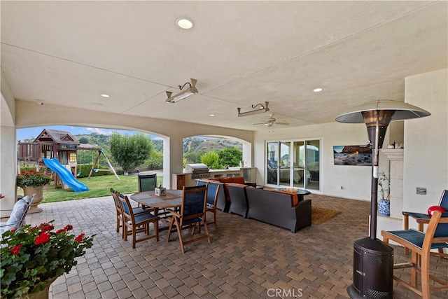 view of patio / terrace featuring ceiling fan, area for grilling, exterior kitchen, and a playground