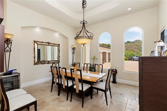 tiled dining room featuring a tray ceiling