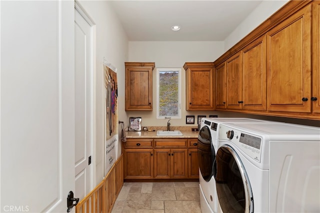 laundry area with sink, washing machine and dryer, cabinets, and light tile patterned floors