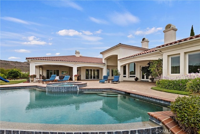 view of swimming pool featuring an in ground hot tub and a patio area