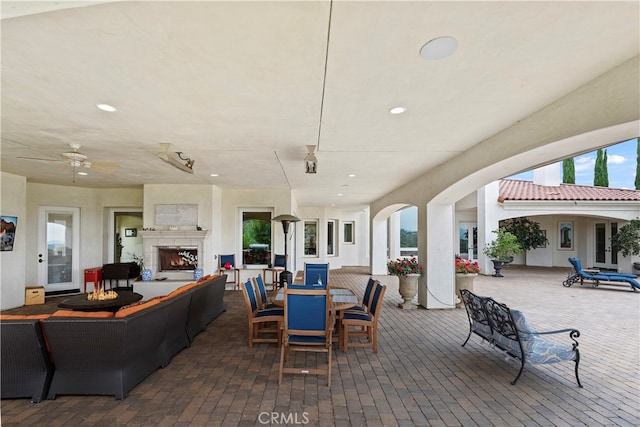 view of patio / terrace featuring an outdoor living space with a fireplace and ceiling fan