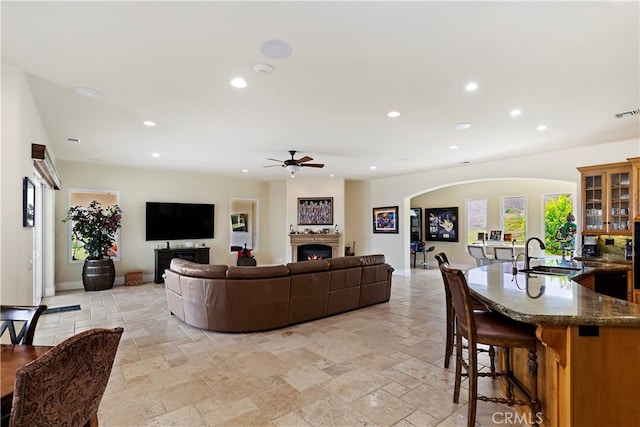 tiled living room featuring sink and ceiling fan