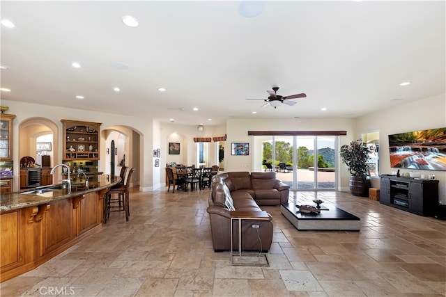 living room with sink, light tile patterned flooring, and ceiling fan