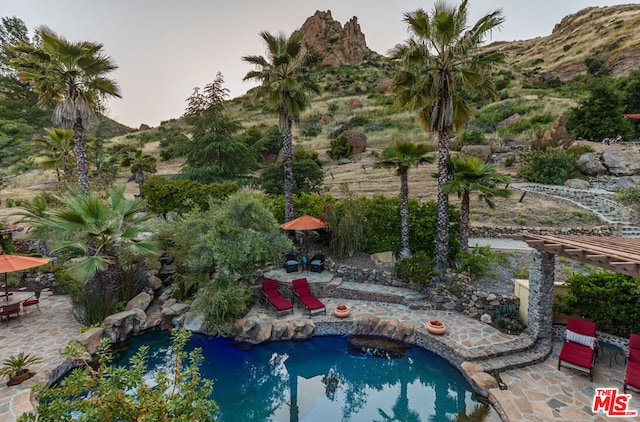 view of swimming pool with a mountain view and a patio