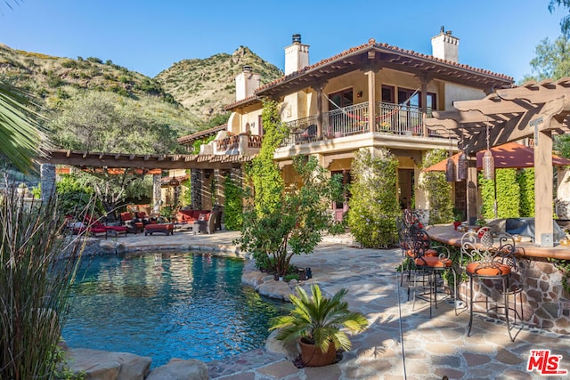 view of pool featuring a mountain view, a pergola, and a patio