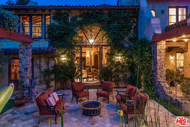 view of patio / terrace featuring a balcony and an outdoor fire pit