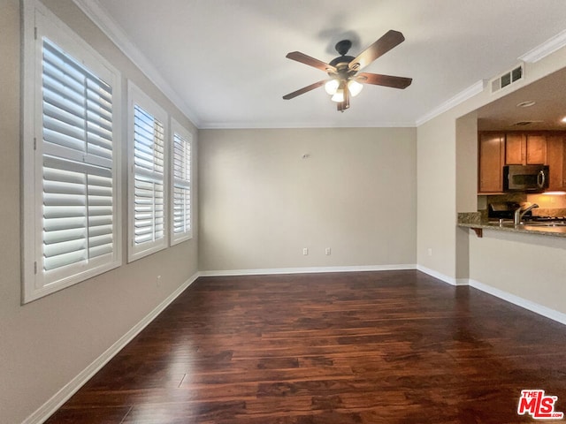 unfurnished living room with ceiling fan, dark hardwood / wood-style flooring, sink, and ornamental molding