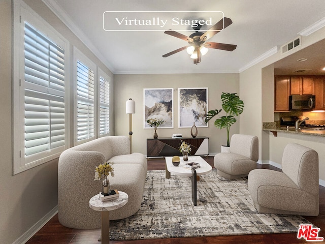 living room featuring dark hardwood / wood-style floors, ceiling fan, and crown molding