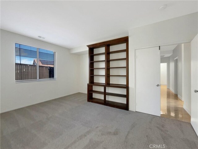 unfurnished bedroom featuring light colored carpet and a closet