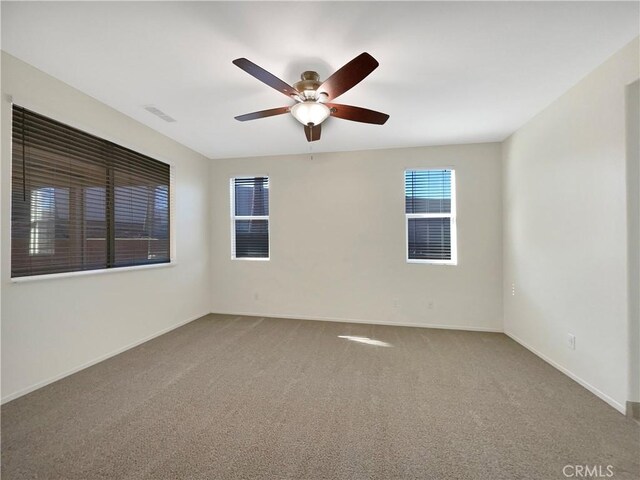 carpeted spare room featuring ceiling fan