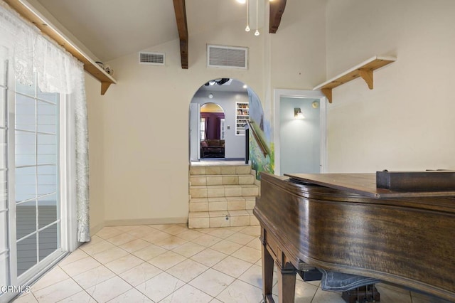 interior space featuring lofted ceiling with beams, light tile patterned flooring, arched walkways, and visible vents