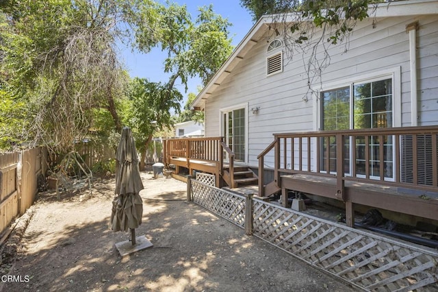 exterior space featuring a deck, a patio, and a fenced backyard