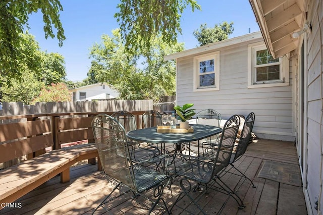 wooden deck with outdoor dining space and fence