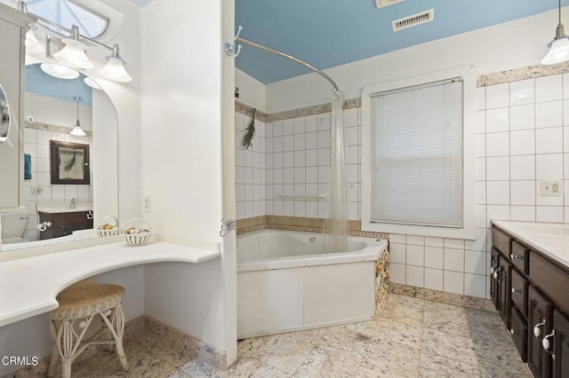 bathroom featuring vanity, tile walls, bathing tub / shower combination, and visible vents