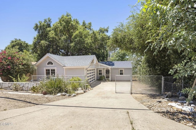 ranch-style house featuring fence, an attached garage, driveway, and a gate