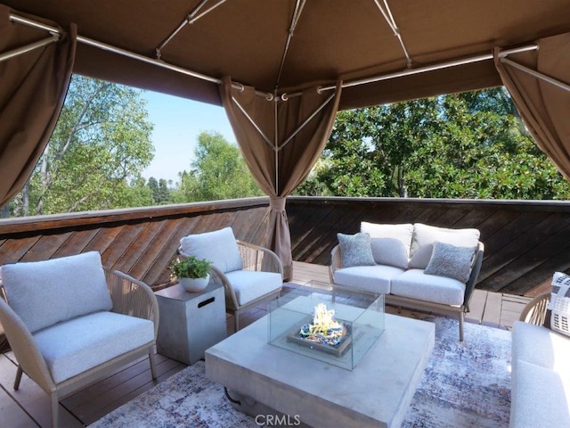 wooden deck featuring an outdoor living space with a fire pit