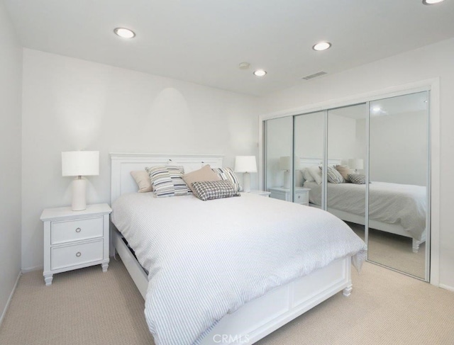 bedroom with light colored carpet and a closet