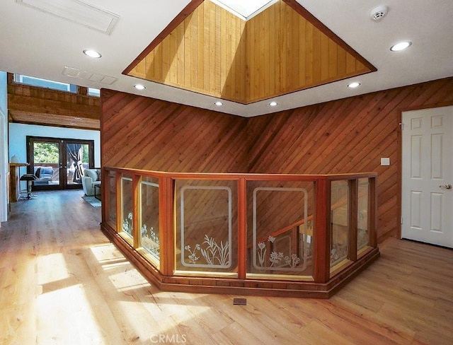 hallway with wood walls and light hardwood / wood-style flooring