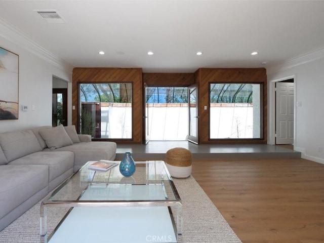 living room with a healthy amount of sunlight, crown molding, and hardwood / wood-style floors