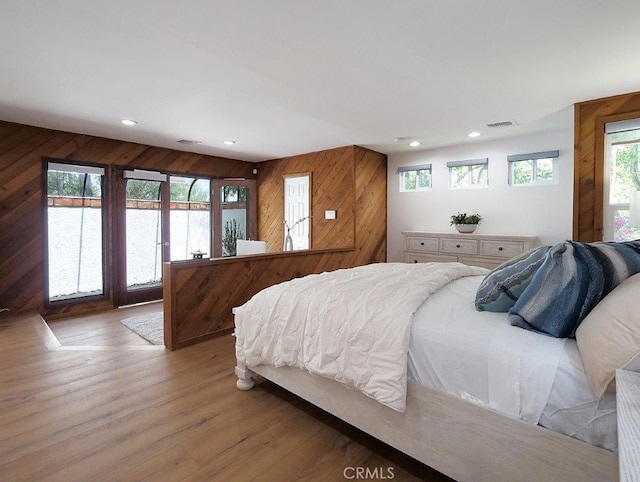 bedroom featuring hardwood / wood-style flooring and wood walls