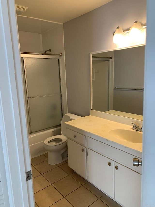 full bathroom featuring tile patterned flooring, shower / bath combination with glass door, toilet, and vanity