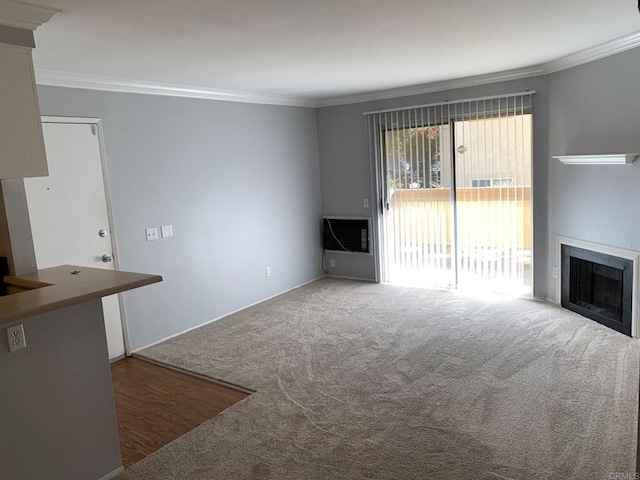 unfurnished living room with ornamental molding and dark colored carpet