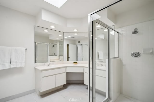 bathroom featuring a shower with door and vanity