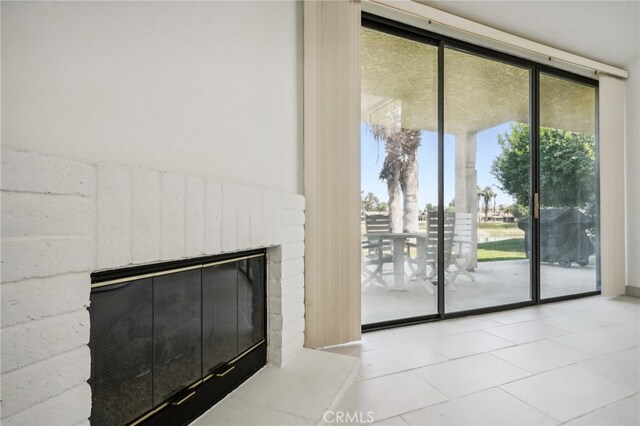 doorway to outside featuring a fireplace and light tile patterned floors