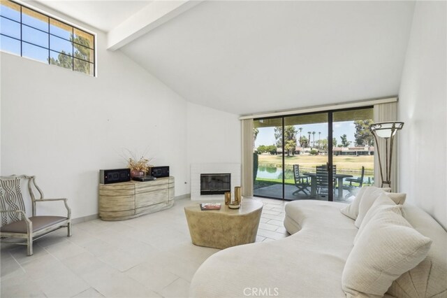 tiled living room featuring beamed ceiling, expansive windows, a water view, and high vaulted ceiling