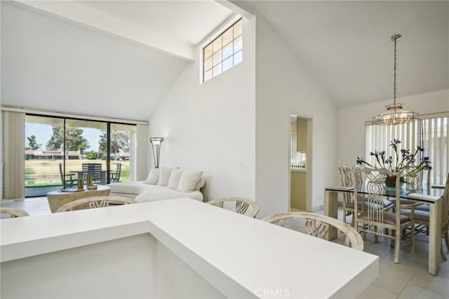 interior space with light tile patterned flooring, a notable chandelier, access to exterior, and high vaulted ceiling