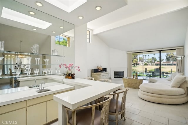 6726 Greenwood Cir, Palm Springs, CA 92264 - kitchen with vaulted ceiling with beams, cream cabinets, sink, pendant lighting, and light tile patterned floors