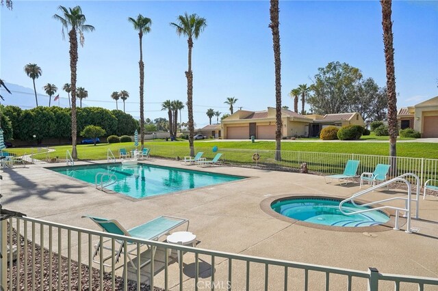 view of pool with a yard, a patio area, and a community hot tub