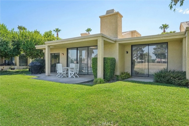 back of property featuring a patio area and a lawn