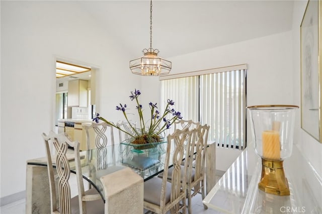 dining space with lofted ceiling and an inviting chandelier